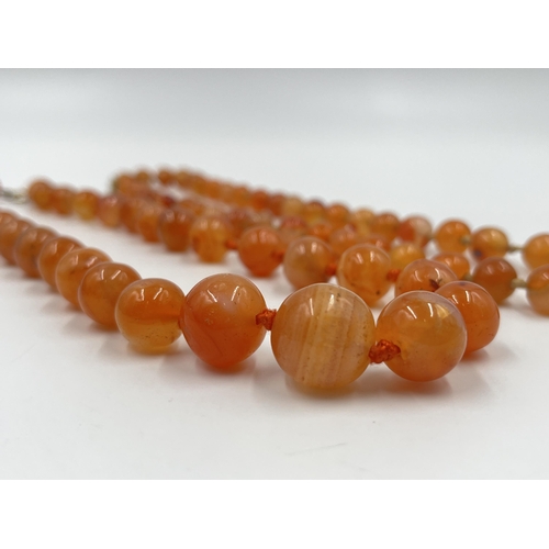 1183 - Two Art Deco carnelian beaded necklaces, one with 9ct gold clasp - approx. gross weight 115 grams