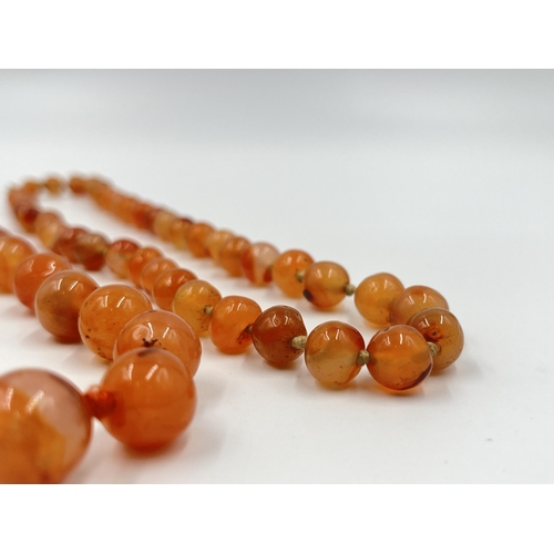 1183 - Two Art Deco carnelian beaded necklaces, one with 9ct gold clasp - approx. gross weight 115 grams