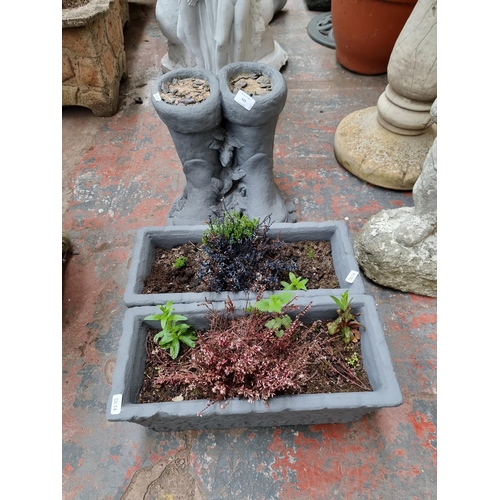 929 - Three grey painted cast stone planters, two rectangular and one pair of wellington boots