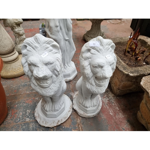 931 - A pair of white painted cast stone seated lion garden ornaments