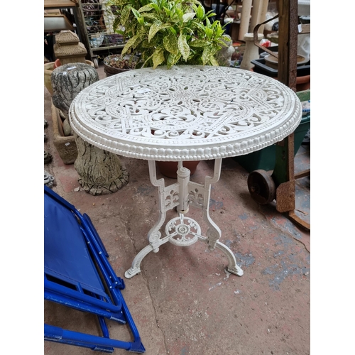 941 - A Coalbrookdale style white painted metal patio table on tri footed base