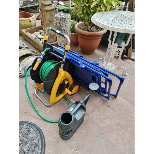 946 - Four garden items, one Toughmaster hose reel with hose, two folding chairs and one watering can