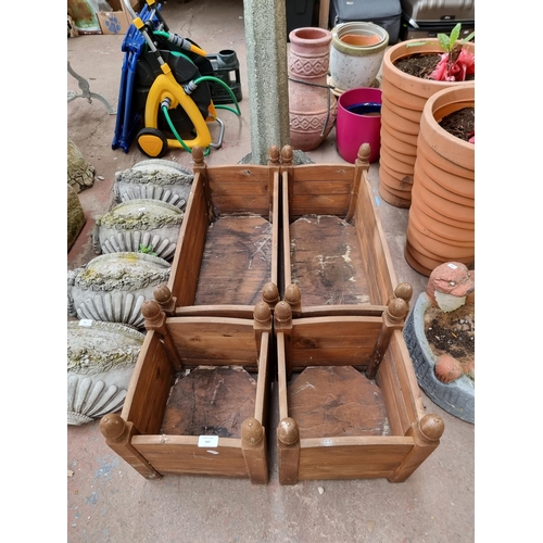 947 - Two pairs of brown painted wooden planters with acorn finials