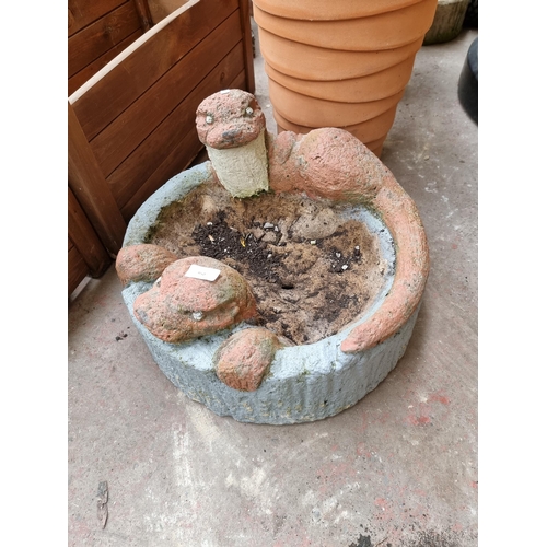 950 - A painted cast stone planter in the form of two otters