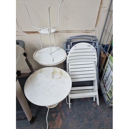 844 - Eight pieces of garden furniture, three white painted metal patio tables and five chairs