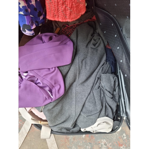 976B - A clothes rail and four suitcases containing a large collection of women's clothing to include Easte... 