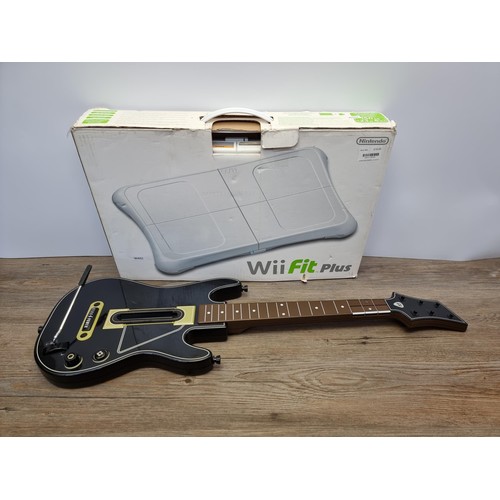 743 - A boxed Nintendo Wii Fit board and Guitar Hero controller