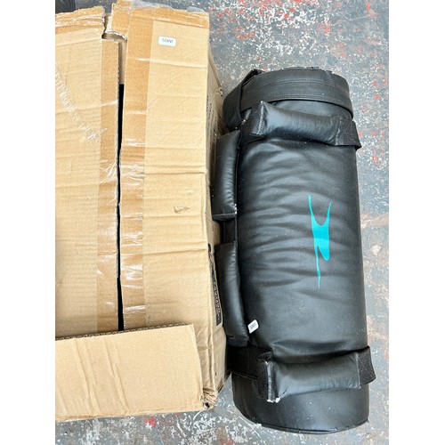 820 - A collection of sport equipment to include cricket bats, pads and stumps, 20kg weight training bags,... 