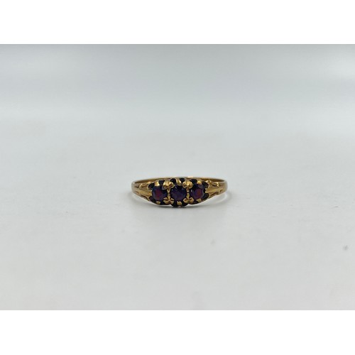 1118 - A 9ct gold garnet trilogy ring - approx. gross weight 1.6 grams