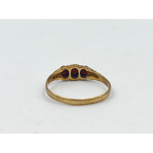 1118 - A 9ct gold garnet trilogy ring - approx. gross weight 1.6 grams