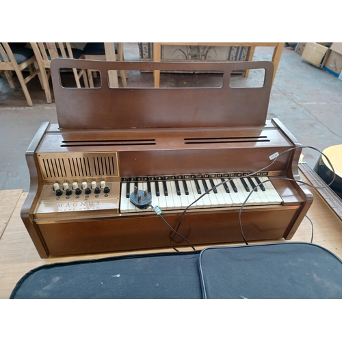 659 - Four musical instruments, one Magnus electric chord organ, one Encore dreadnought electro-acoustic s... 