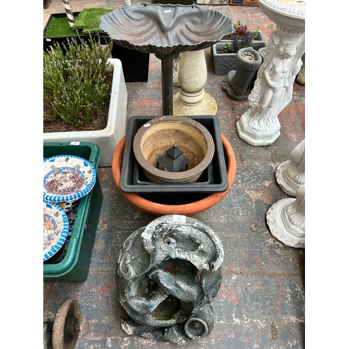 935 - A collection of garden items to include fibre glass water feature with pump, scalloped bird bath on ... 