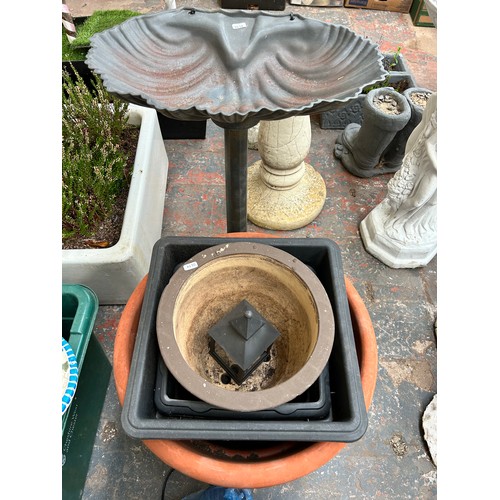 935 - A collection of garden items to include fibre glass water feature with pump, scalloped bird bath on ... 