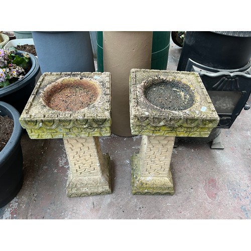 924 - A pair of cast stone bird baths on pedestal bases