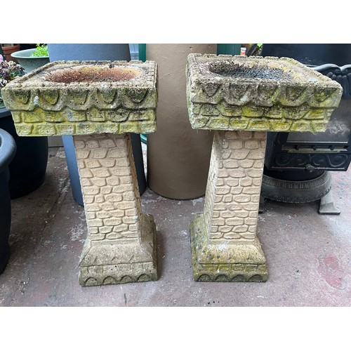 924 - A pair of cast stone bird baths on pedestal bases