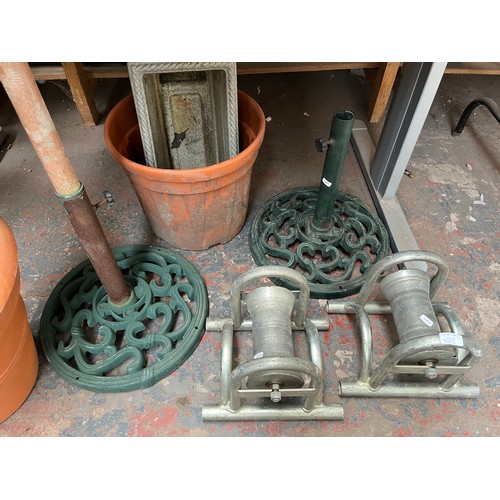 960C - Seven items to include two Victorian style green painted cast iron parasol bases, two heavy duty cab... 