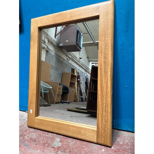 213A - A modern solid oak framed wall mirror - approx. 81cm x 59cm