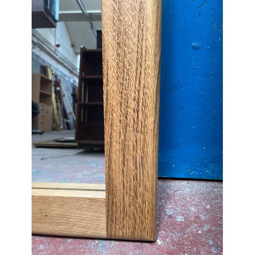 213A - A modern solid oak framed wall mirror - approx. 81cm x 59cm