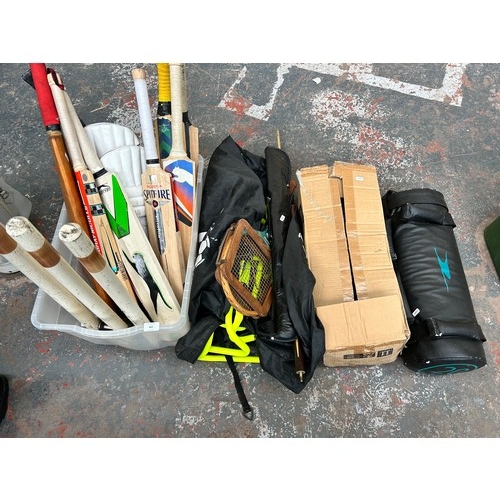 820 - A collection of sport equipment to include cricket bats, pads and stumps, 20kg weight training bags,... 