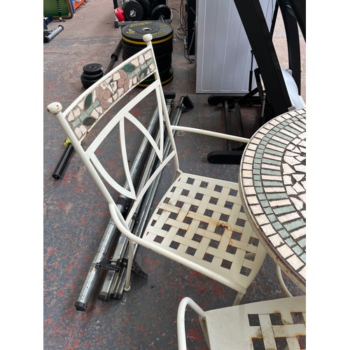 842 - A cream painted metal and mosaic four piece patio set comprising two armchairs, two seater bench and... 