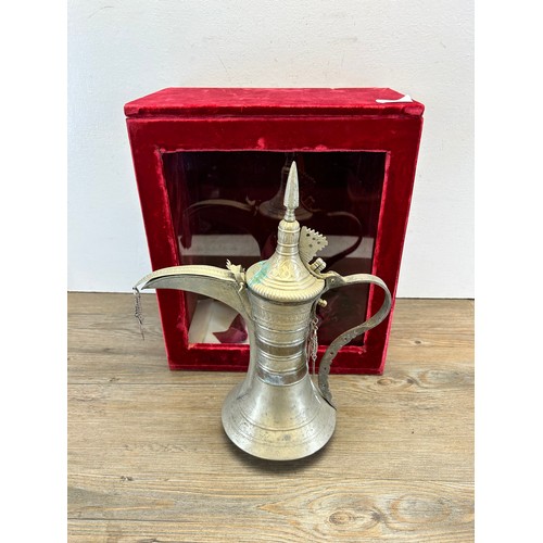 549A - A red velvet cased Middle Eastern metal coffee pot