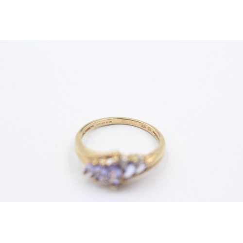 1008 - A 9ct gold diamond and tanzanite eight stone bypass ring - approx. gross weight 2.4 grams