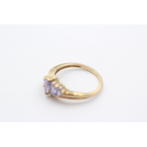 1008 - A 9ct gold diamond and tanzanite eight stone bypass ring - approx. gross weight 2.4 grams