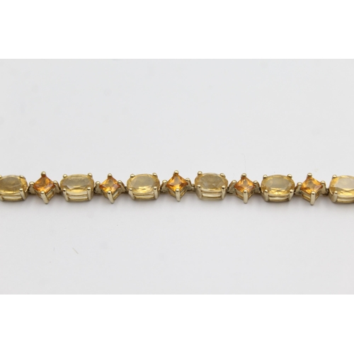 1012 - A 9ct gold citrine and topaz tennis chain bracelet - approx. gross weight 6.4 grams