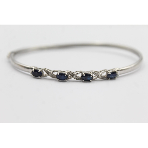 1094 - A 9ct white gold sapphire and diamond bangle - approx. gross weight 4.7 grams