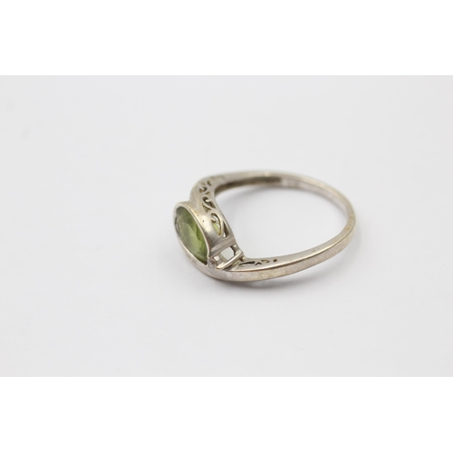 1139 - A 9ct white gold peridot and diamond bypass two stone ring, size M - approx. gross weight 2.3 grams