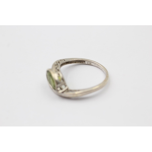 1139 - A 9ct white gold peridot and diamond bypass two stone ring, size M - approx. gross weight 2.3 grams