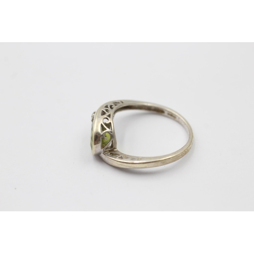 1139 - A 9ct white gold peridot and diamond bypass two stone ring, size M - approx. gross weight 2.3 grams