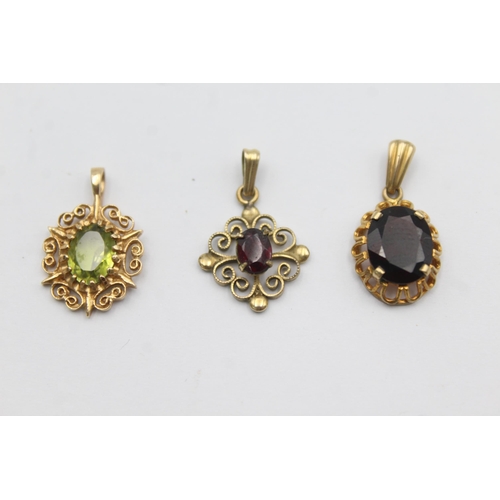 1142 - Three 9ct gold gemstone set pendants, two garnet and one peridot - approx. gross weight 3.5 grams