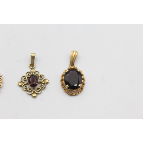 1142 - Three 9ct gold gemstone set pendants, two garnet and one peridot - approx. gross weight 3.5 grams