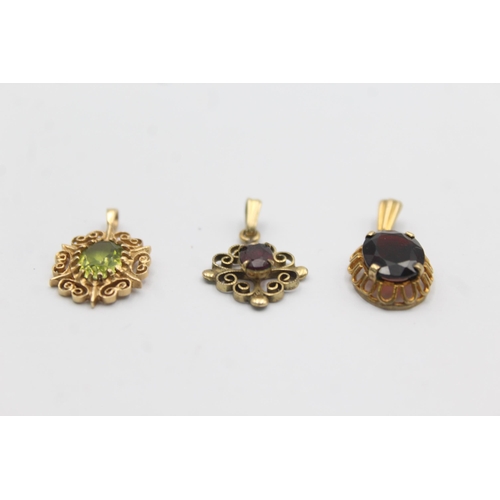 1142 - Three 9ct gold gemstone set pendants, two garnet and one peridot - approx. gross weight 3.5 grams