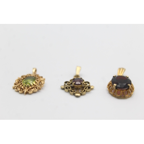 1142 - Three 9ct gold gemstone set pendants, two garnet and one peridot - approx. gross weight 3.5 grams