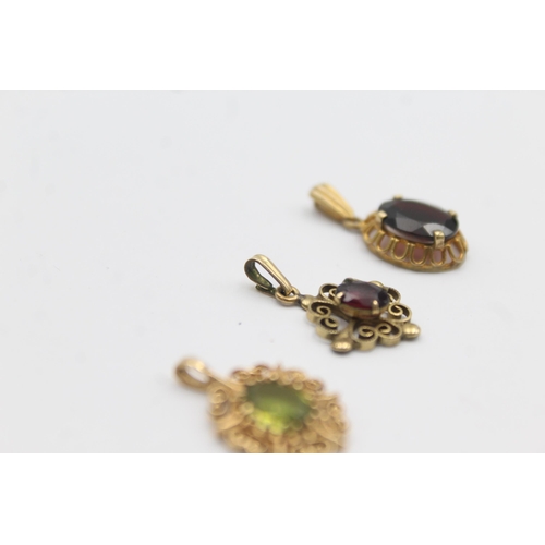 1142 - Three 9ct gold gemstone set pendants, two garnet and one peridot - approx. gross weight 3.5 grams