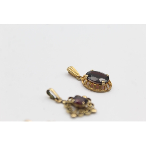 1142 - Three 9ct gold gemstone set pendants, two garnet and one peridot - approx. gross weight 3.5 grams