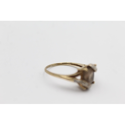 1145 - A 9ct gold smoky quartz and diamond stylised twist setting ring - approx. gross weight 2.3 grams