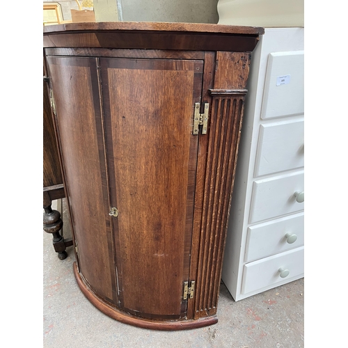 105 - A Georgian oak and mahogany crossbanded bow front wall mountable corner cabinet