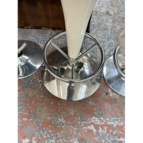 114 - A modern white plastic and chrome plated circular bar table and two black plastic bar stools