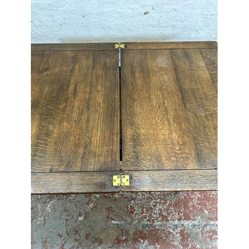 125 - A Georgian style oak fold over dining table with cabriole supports