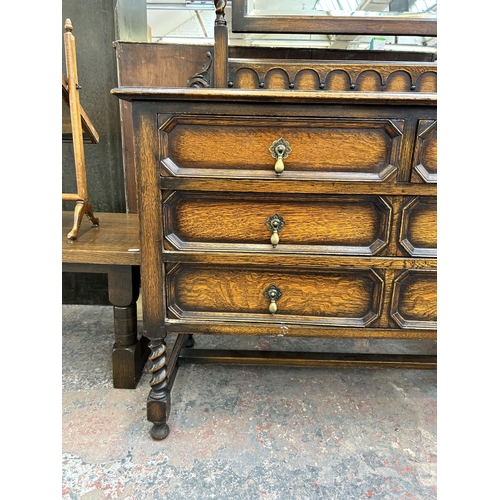 138 - An early 20th century oak dressing table with three drawers, upper bevelled edge mirror and barley t... 