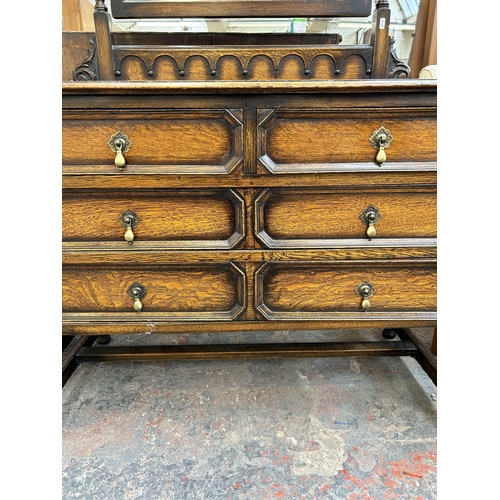 138 - An early 20th century oak dressing table with three drawers, upper bevelled edge mirror and barley t... 