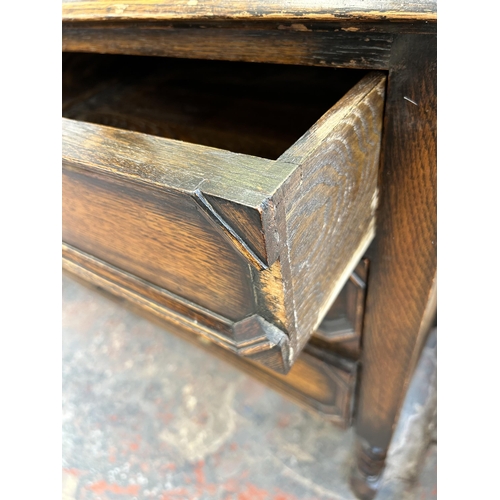 138 - An early 20th century oak dressing table with three drawers, upper bevelled edge mirror and barley t... 