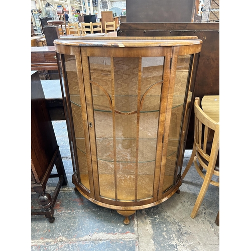 22 - A walnut bow fronted display cabinet with single glazed door and cabriole supports