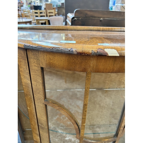 22 - A walnut bow fronted display cabinet with single glazed door and cabriole supports