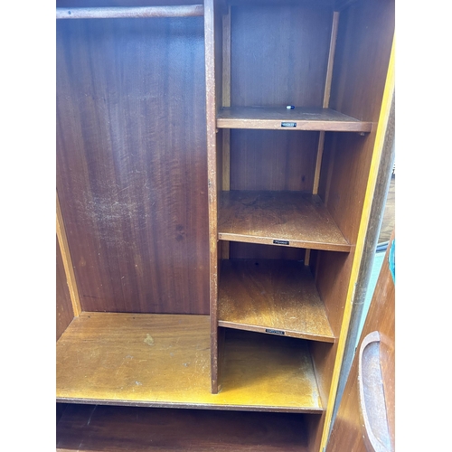 23 - An Austinsuite walnut three piece bedroom suite comprising two double wardrobes and dressing table