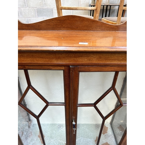 32 - A mahogany display cabinet with two glazed doors and bracket supports