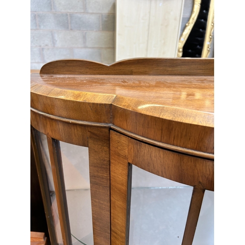 35 - A walnut bow fronted display cabinet with single glazed door and cabriole supports